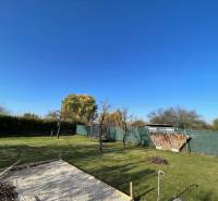 Garten bei der Hütte in der Neuen Siedlung in Komárno mit Rasen und Feuerstelle.