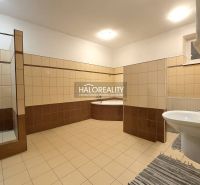 Schlafzimmer im Einfamilienhaus mit Bett, Schränken und Boden in Holzoptik.