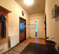 Schlafzimmer in einem Einfamilienhaus mit Bett, Fernseher auf einem Schrank und Boden mit Holzdekor.
