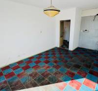 Ein Zimmer in einer Einzimmerwohnung mit einem farbigen Fliesenboden und einer Hängelampe.