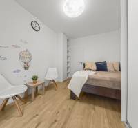 Schlafzimmer in einer 2-Zimmer-Wohnung mit Wanddekor und Holzboden.