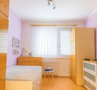 Helles Schlafzimmer in einer Zweizimmerwohnung mit einer Kommode mit Schubladen und einem Einbauschrank.