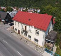 Das Gebäude in Belej mit dem roten Dach, die umliegenden Häuser und die Natur.