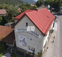 Das Gebäude des Gasthauses in Belá mit rotem Dach und einer Darstellung an der Wand.