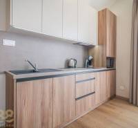 Küche in einer 2-Zimmer-Wohnung mit Holzboden und heller Küchenzeile.