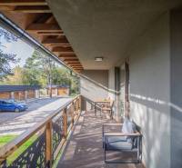 Balkon einer 2-Zimmer-Wohnung in Tatranská Lomnica mit Holzimitation und Außensitzbereich.