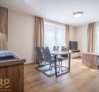 Geräumiges Interieur einer 2-Zimmer-Wohnung mit Holzboden und Esstisch.