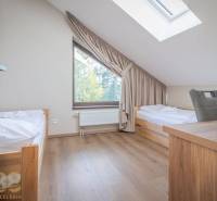 Schlafzimmer in einer 2-Zimmer-Wohnung mit zwei Betten und einem Boden in Holzoptik.