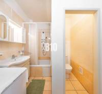 Badezimmer in einer 4-Zimmer-Wohnung mit Badewanne, Schränken und Toilette, in hellen Farben gehalten.