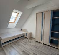 Kinderzimmer mit Dachfenster, Bett und Schrank in einer 4-Zimmer-Wohnung.