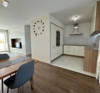 Essbereich in einer 4-Zimmer-Wohnung mit Holzboden und Küche im Hintergrund.