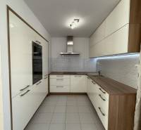 Küche in einer 4-Zimmer-Wohnung mit hellen Schränken und Fliesenboden.