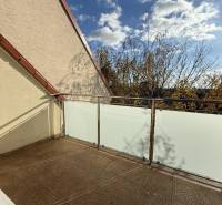 Balkon einer 4-Zimmer-Wohnung in der Pekníkova-Straße in Pezinok mit Blick auf die Baumwipfel.