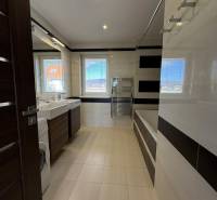 Badezimmer in einer 4-Zimmer-Wohnung mit Badewanne, Waschbecken und Waschmaschine.