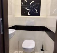 Badezimmer mit hängendem WC und Waschbecken in einer 4-Zimmer-Wohnung, verziert mit Blumenmotiven.