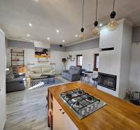 Innenraum eines Einfamilienhauses mit Kamin und Küche, Boden mit Holzdekor.