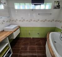 Badezimmer in einem Einfamilienhaus mit Holzboden, Waschbecken und Badewanne.