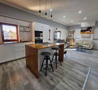 Einfamilienhaus mit Holzboden, Küche und Wohnzimmer mit bequemen Sitzgelegenheiten.