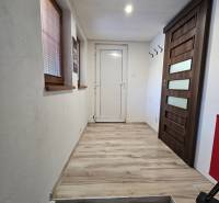 Ein Flur in einem Einfamilienhaus mit einem Boden in Holzoptik und hellen Wänden.