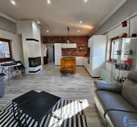 Wohnzimmer in einem Einfamilienhaus mit Kamin, Holzelementen und Sitzgarnituren.