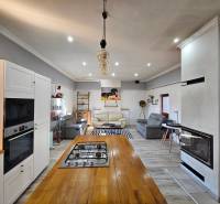 Eine Küche in einem Einfamilienhaus mit einem Herd, weißen Schränken und einem Boden in Holzoptik.