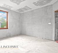 Ein unvollendeter Raum in einem Einfamilienhaus mit Betonboden und einem großen Fenster.