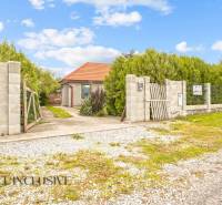 Ein Einfamilienhaus in Bátorové Kosihy, umgeben von Grün, mit einem Weg, der zum Tor führt.