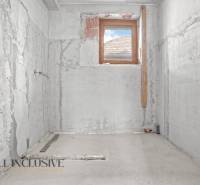 Badsanierung in einem Einfamilienhaus, Wände aus unbehandeltem Beton, nur ein kleines Fenster.