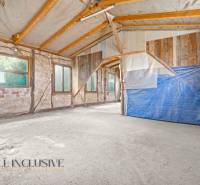 Innenraum eines Einfamilienhauses mit rohen Wänden und Holzbalken.