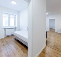 Helle 3-Zimmer-Wohnung mit Bett und Boden in Holzoptik.