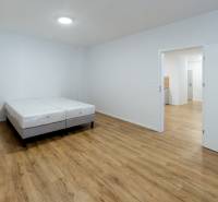 Schlafzimmer in einer 3-Zimmer-Wohnung mit einem Bett und einem Boden in Holzoptik.