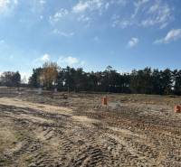 Grundstücke zum Wohnen in der Straße Pod Borovicou in Studienka, umgeben von Bäumen und blauem Himmel.