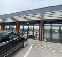 Geschäftsräume in der Brnianska-Straße in Trenčín mit Glasfassade und Parkplatz.