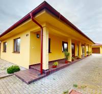 Ein Einfamilienhaus in der Ďatelinová-Straße in Iža mit gepflegtem Hof und Kletterpflanzen.