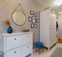 Ein Flur in einem Einfamilienhaus mit Spiegel, Dekorationen und Stauraum.