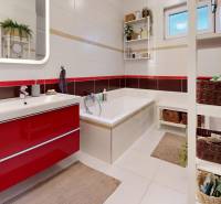 Badezimmer in einem Einfamilienhaus mit Badewanne, Waschbecken und Aufbewahrungskörben.