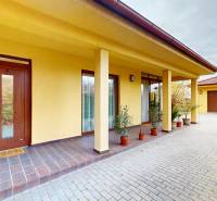 Ein Einfamilienhaus in der Ďatelinová-Straße in Iža mit Garage und Arkaden, umgeben von Grün.