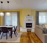 Wohnzimmer mit Kamin, Esstisch und Holzboden in einem Einfamilienhaus.