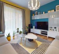 Wohnzimmer in einem Einfamilienhaus mit bunten Wänden, Holzboden und Zimmerpflanzen.