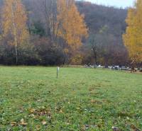 Grüne Erholungsgrundstücke im Herbst in Podhradí, Konské, mit bunten Laubbäumen im Hintergrund.