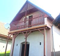 Ein Ferienhaus in Hontianske Trsťany mit einem Holzbalkon und einer Satellitenschüssel.