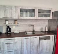 Küche in einer 2-Zimmer-Wohnung mit einem roten Kühlschrank und einem Boden in Holzoptik.