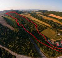 Luftaufnahme von landwirtschaftlichen und forstwirtschaftlichen Flächen bei Rokycany, umgeben von Grünflächen und einer Straße.