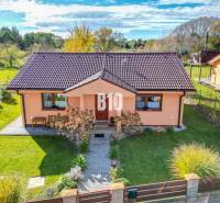 Ein Einfamilienhaus in Bílkove Humence mit gepflegtem Garten und terrakottafarbener Fassade.