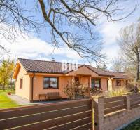 Ein Einfamilienhaus in Bíkové Humence mit einem Vorgarten und Bäumen auf einem gepflegten Grundstück.