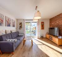 Wohnzimmer in einem Einfamilienhaus mit Sofa, Ziegelwand und Holzboden.