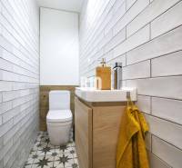 Ein schmales Badezimmer mit Fliesen, Toilette und Waschbecken in einer 3-Zimmer-Wohnung.