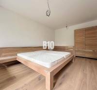 Schlafzimmer in einer 2-Zimmer-Wohnung mit einem Holzbett und einem Schrank auf einem Holzboden.