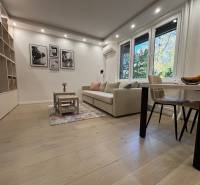 Wohnzimmer in einer 2-Zimmer-Wohnung, großes Sofa, Tisch, Boden mit Holzdekor.