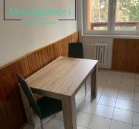 Essbereich in einer 2-Zimmer-Wohnung mit Holzdekor an den Wänden und Fliesenboden.